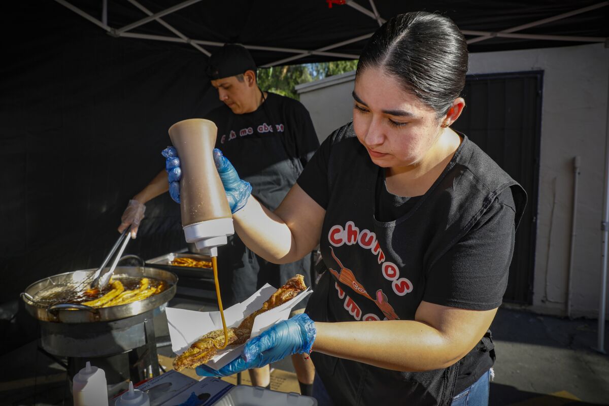 Baltazar Flores and Zamata Aguilera, owners of Churros con Amor, work frying churros from a "Pop up" tent off in Chula Vista.