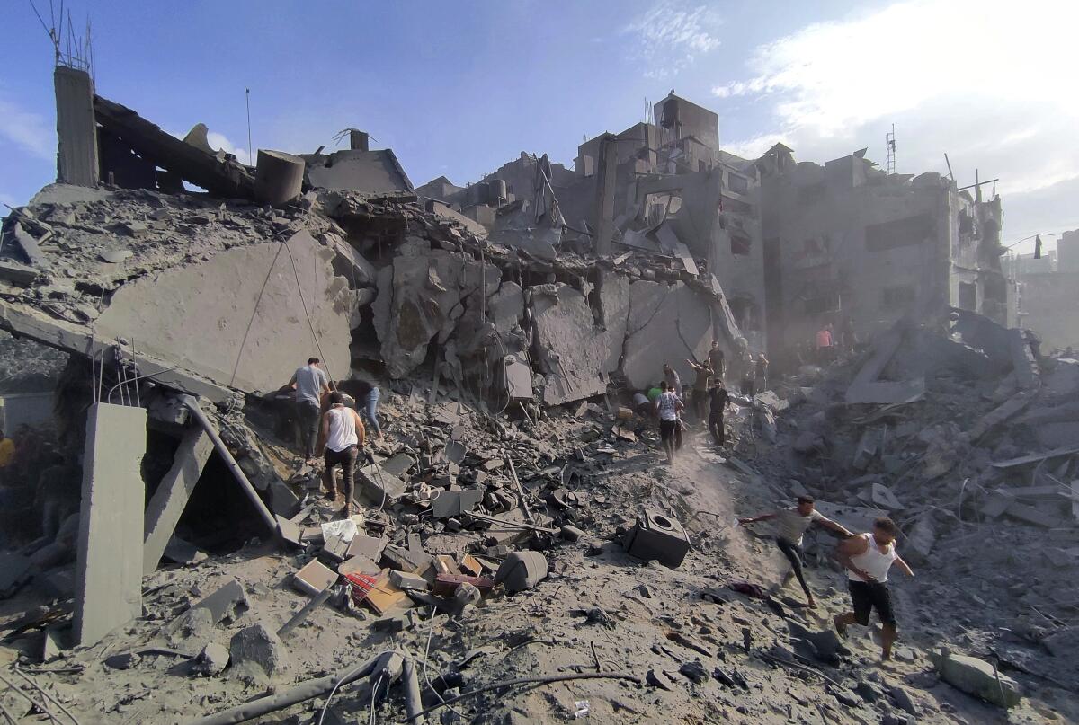 Palestinos inspeccionan los daños en los edificios destruidos por ataques aéreos israelíes