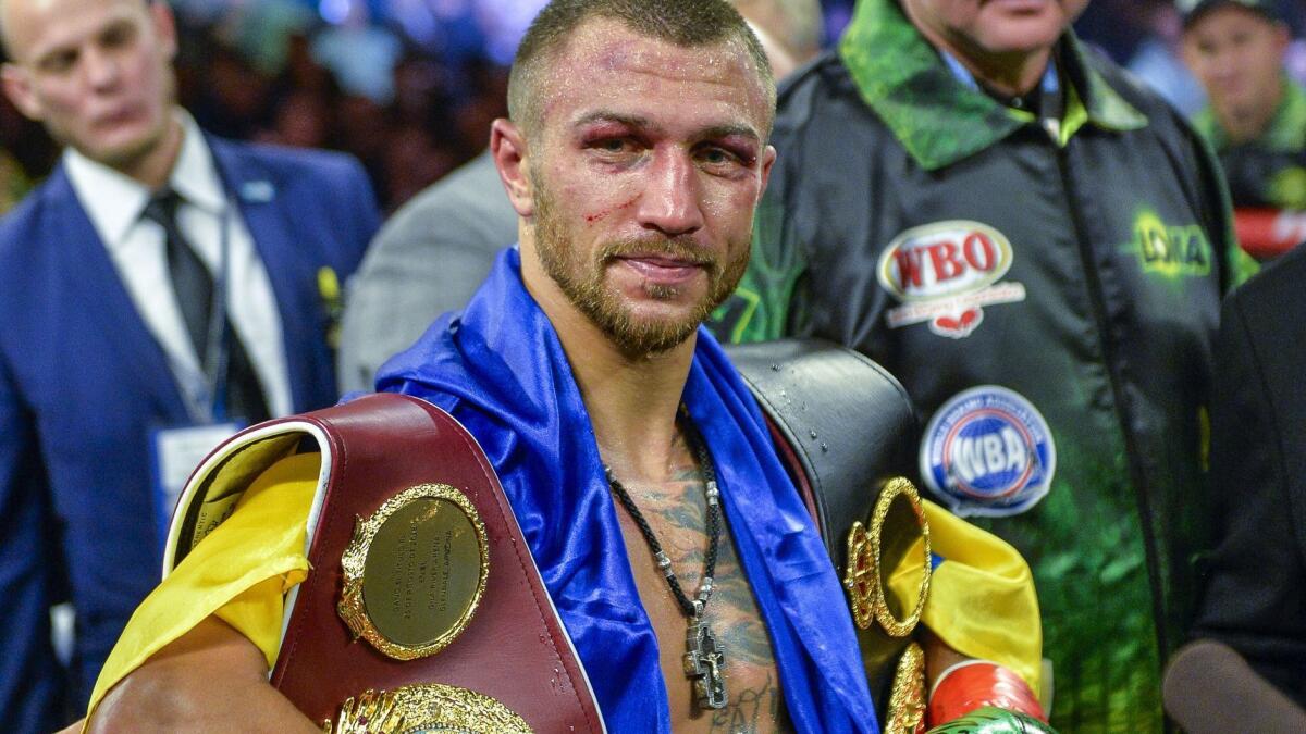 Vasiliy Lomachenko poses with the belts after defeating Jose Pedraza in the WBO title lightweight boxing match at Madison Square Garden on Dec. 8, 2018.