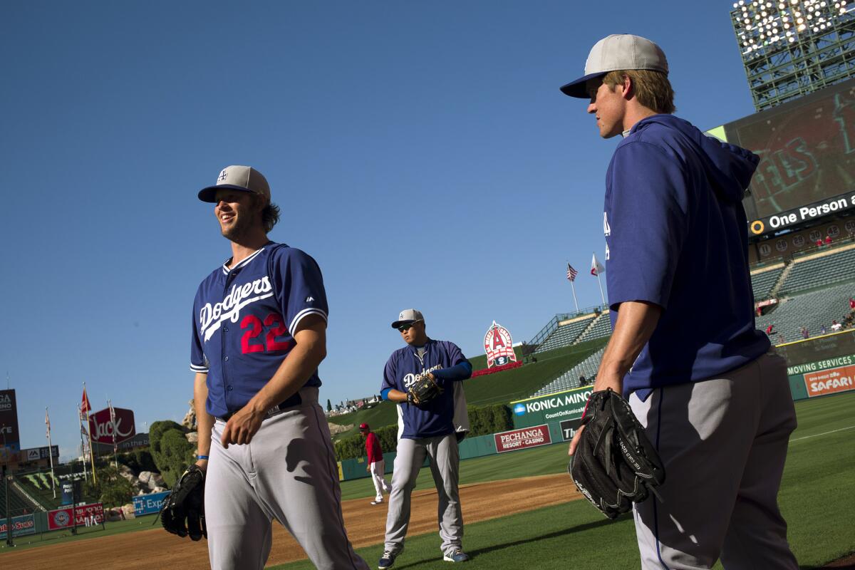 Clayton Kershaw and Zack Greinke share a moment before a game this season.