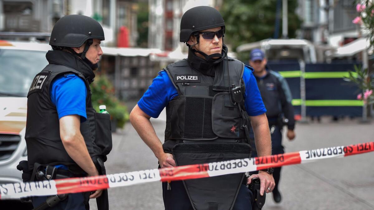 Officers stand guard behind a police cordon in the old quarter of Schaffhausen, northern Switzerland, on July 24, 2017, after a man armed with a chainsaw injured at least five people in an attack.