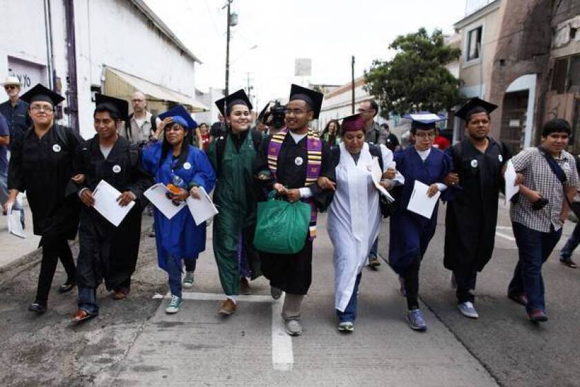 The "Dream 9," eight of them wearing graduation caps and gowns to show their desire to finish school in the U.S., march to a U.S. port of entry last month.