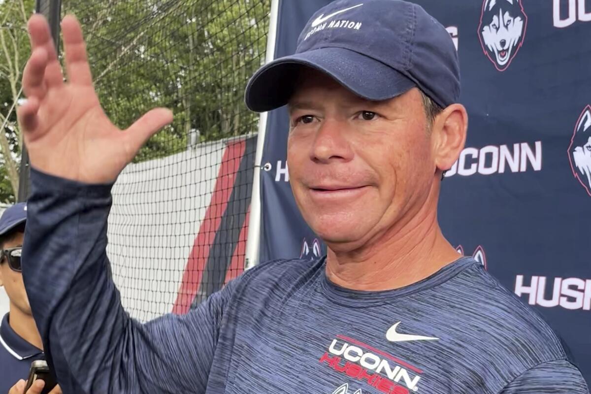 Connecticut head football coach Jim Mora speaks to reporters during the opening day of NCAA college football training camp on July 29, 2022, in Storrs, Conn. Mora is trying to rebuild the football program as an independent in an era of conference mega-mergers.(AP Photo/Pat Eaton-Robb)