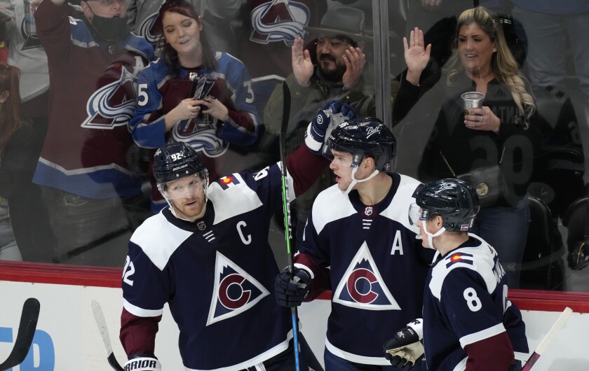 Colorado Avalanche right wing Mikko Rantanen, center, is congratulated after scoring a goal by left wing Gabriel Landeskog, left, and defenseman Cale Makar in the third period of an NHL hockey game against the Chicago Blackhawks Monday, Jan. 24, 2022, in Denver. The Avalanche won 2-0. (AP Photo/David Zalubowski)