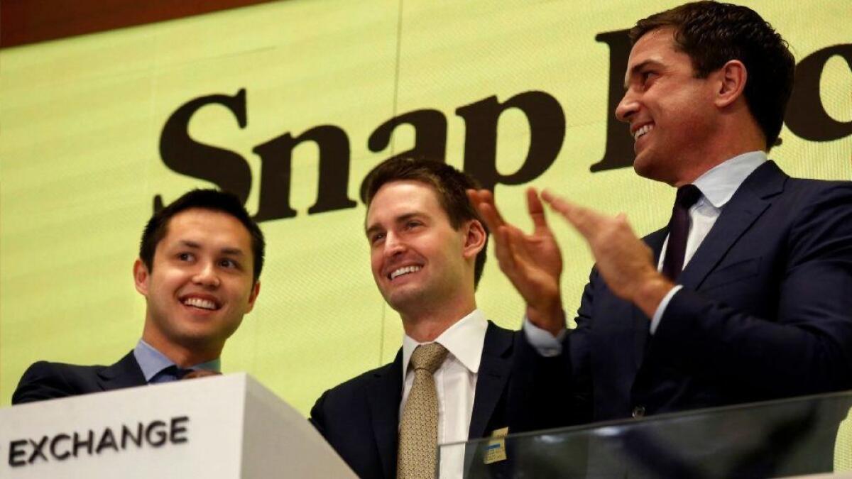 Snap Inc. CEO Evan Spiegel, center, rings the bell at the New York Stock Exchange last year as the company made its stock market debut.