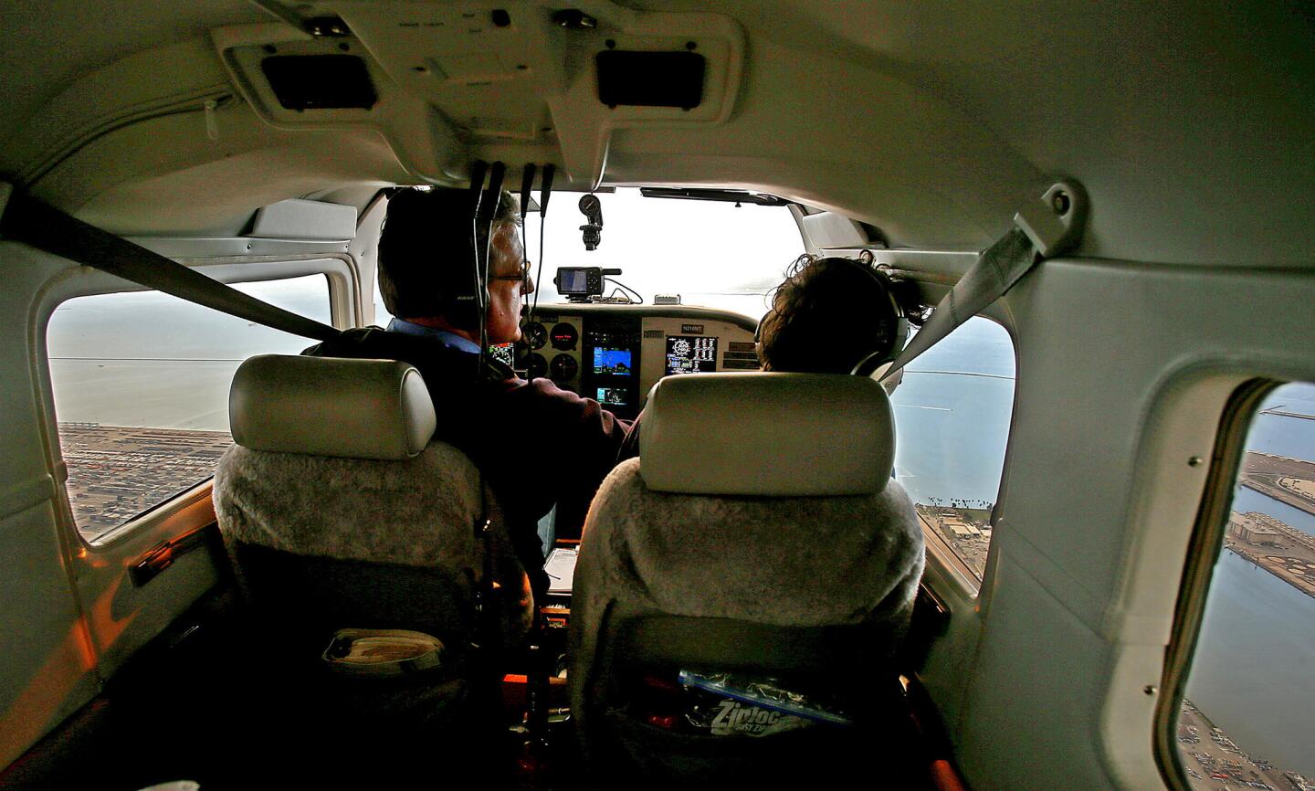 Mike Sutton, left, head of the California Fish and Game Commission, pilots a single engine aircraft over the Port of Los Angeles on his way to Southern California's Marine Protected Areas around the Palos Verdes Peninsula and Point Dume. Flying with him is Ana Luisa Ahern of environmental group Heal the Bay.