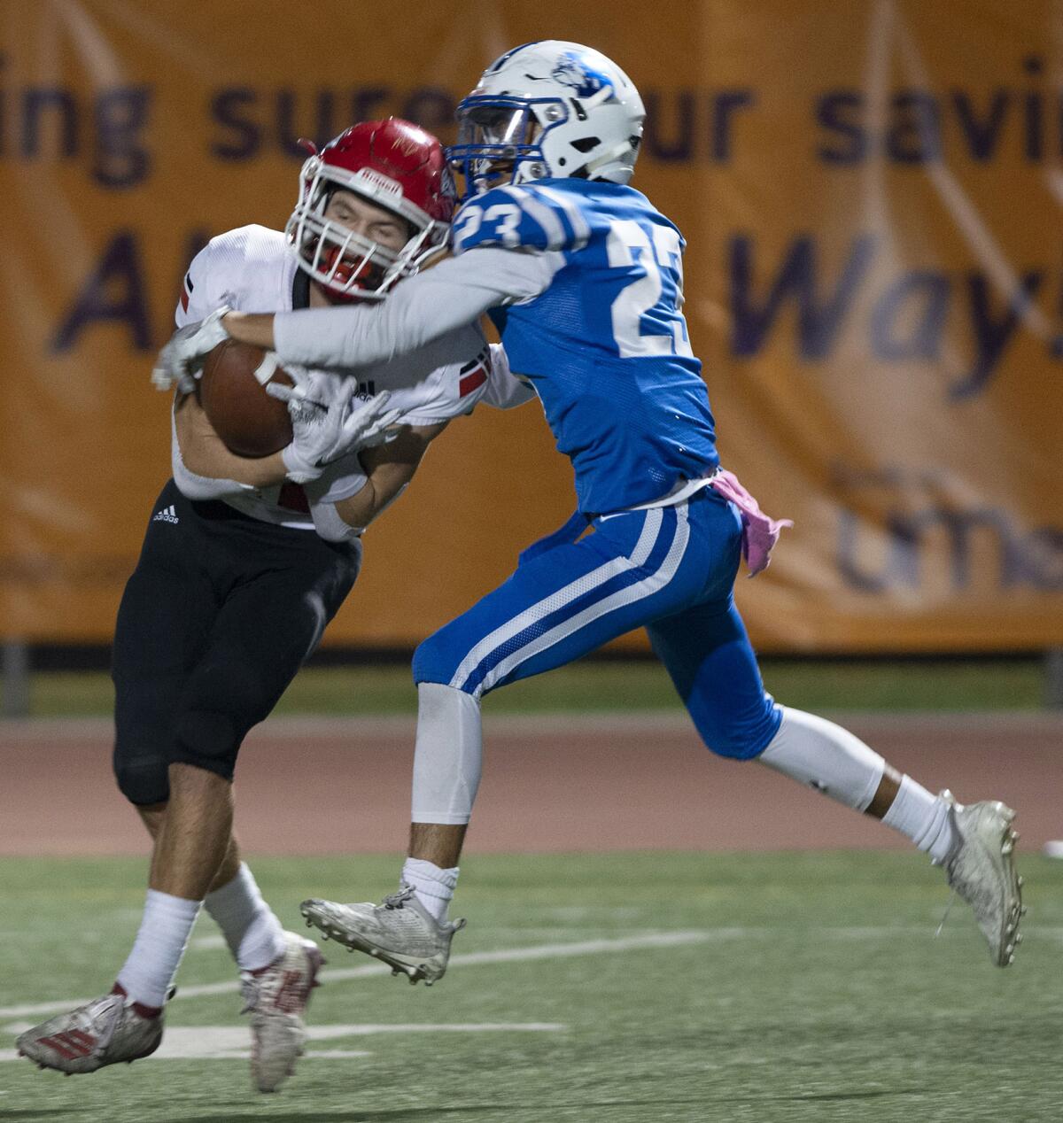 Burroughs’ Aiden Forrester pulls in a long pass while under heavy pressure form Burroughs’ Kaze Gibbs during Friday's homecoming game at Memorial Field. (Photo by Miguel Vasconcellos)