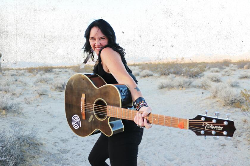 Astra Kelly poses with a guitar.