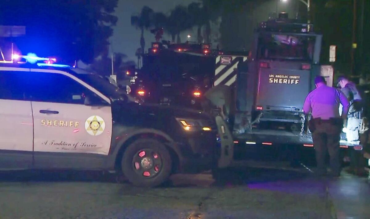 Emergency responder vehicles are parked on a street at night.