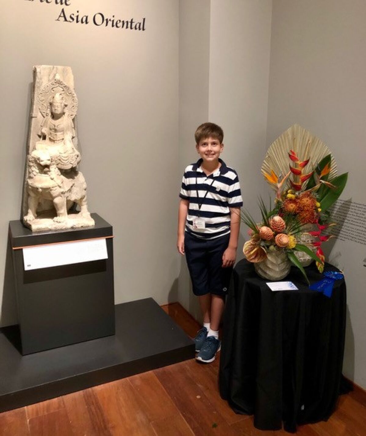 Marcel Halldorson poses with his award-winning floral arrangement for Art Alive and the sculpture he used for inspiration.
