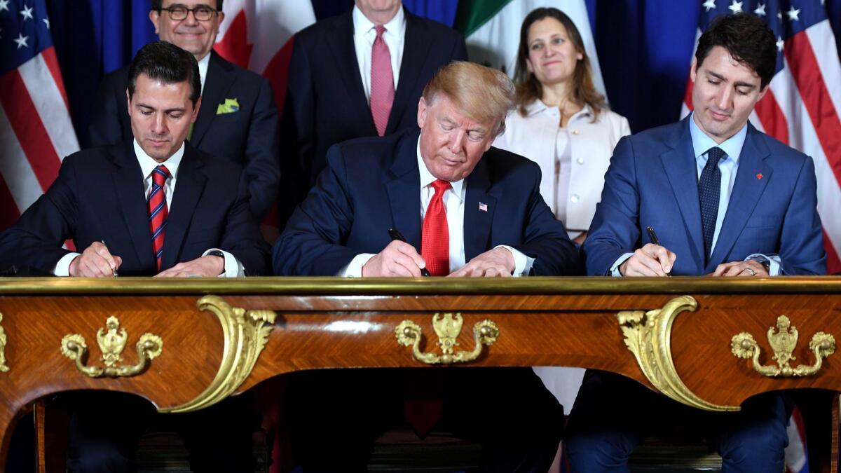 Former Mexican President Enrique Pena Nieto, President Trump and Canadian Prime Minister Justin Trudeau sign a trade agreement in 2018.