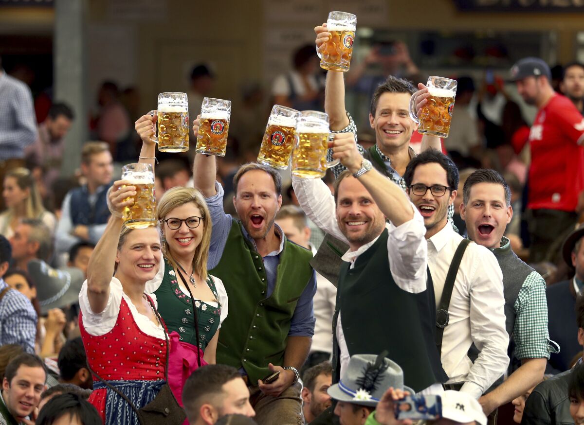 FILE - In this Saturday, Sept. 21, 2019 file photo, visitors lift glasses of beer during the opening of the 186th 'Oktoberfest' beer festival in Munich, Germany. The annual Oktoberfest festival is finally on again for this fall, following a two-year hiatus due to the coronavirus pandemic. The head of the famous Bavarian beer festival in Munich said Thursday the celebrations will be held without any pandemic restrictions from Sept. 17 to Oct. 3, 2022. (AP Photo/Matthias Schrader, file)