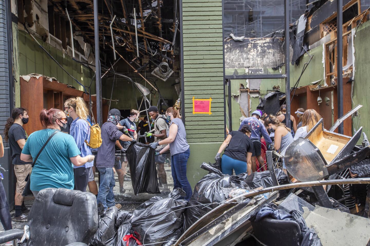 Volunteers help clean up a looted store in Long Beach.