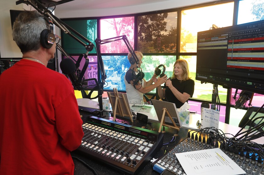 Barbara McMurray, center, and Laguna Beach Mayor Sue Kempf, right, prepare to host a show with Ed Steinfeld on the board.