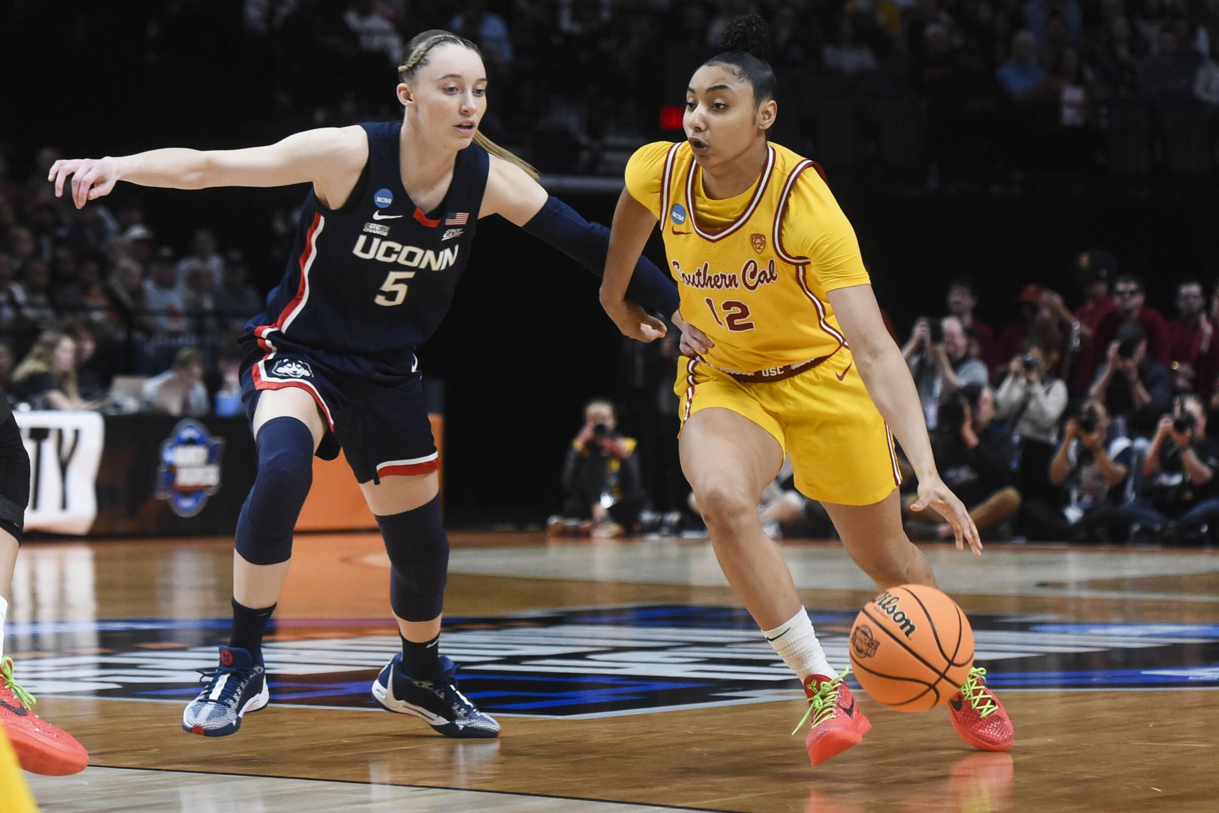 USC guard JuJu Watkins drives to the basket past Connecticut guard Paige Bueckers.