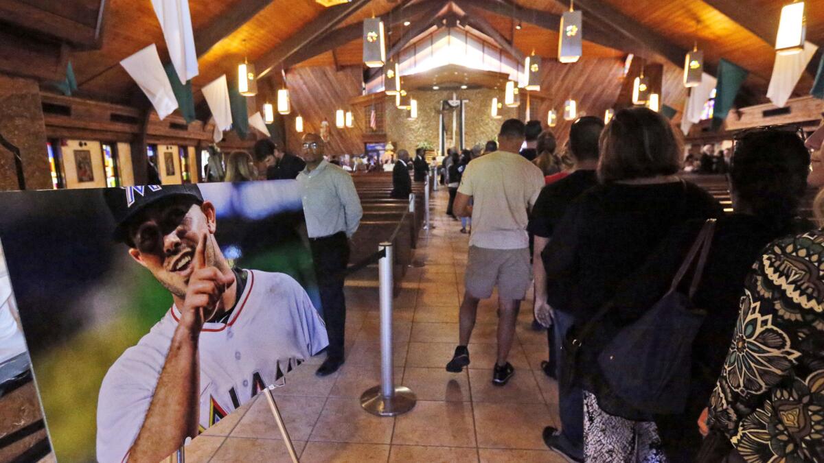 Mourners file past a photo of Marlins pitcher Jose Fernandez during a memorial service at St. Brendan's Catholic Church in Miami on Wednesday.