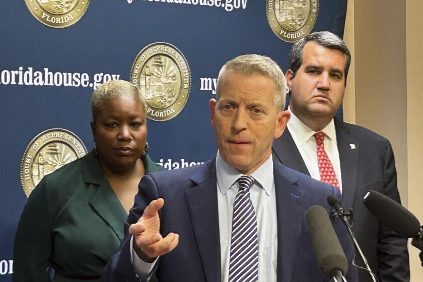 Florida's Republican House Speaker Paul Renner discusses Gov. Ron DeSantis' veto of a bill that would have banned kids under 16 from social media regardless of parental consent, in Tallahassee, Fla., Friday, March 1, 2024. A new proposal lowers that age to 14. He was joined by Democratic Rep. Michele Rayner, left, and Republican Rep. Tyler Sirois, right. (AP Photo/Brendan Farrington)