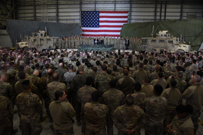 Troops inside a hangar with an American flag