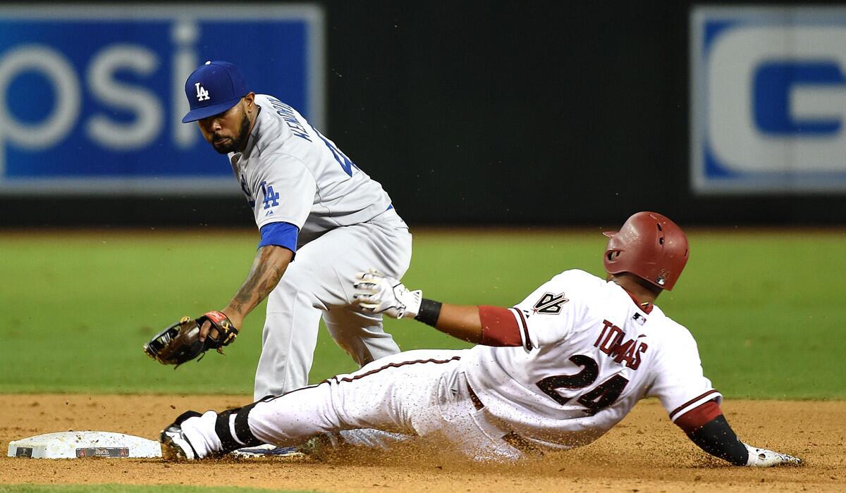 Dodgers' Howie Kendrick, left, tags out Diamondbacks' Yasmany Tomas at second base during the ninth inning on Tuesday.