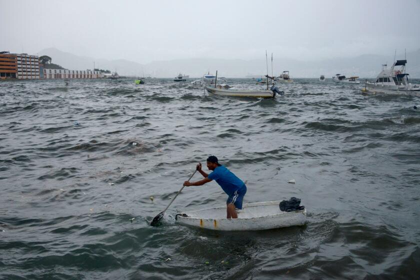 A man rows his boat in Acapulco, Guerrero State, Mexico, on August 16, 2023, following the passage of Tropical Storm Hilary. (Photo by FRANCISCO ROBLES / AFP) (Photo by FRANCISCO ROBLES/AFP via Getty Images)