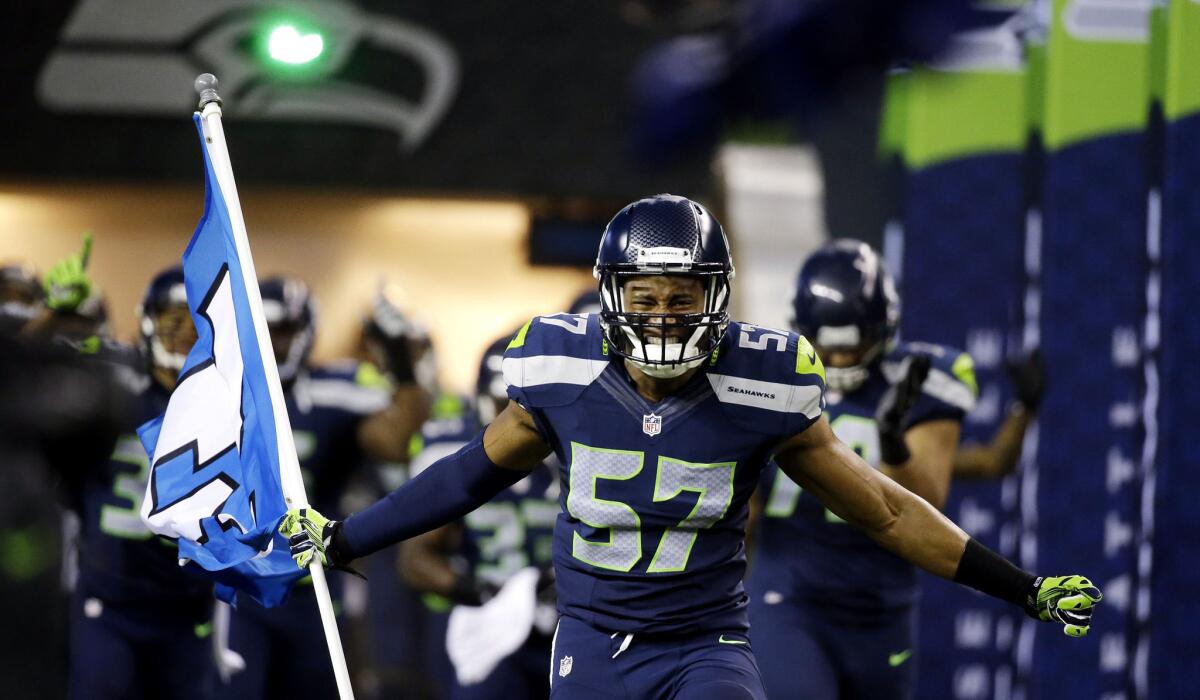 Linebacker Mike Morgan (57) leads the Seahawks onto the field for their NFL divisional playoff game against the Carolina Panthers on Saturday in Seattle.