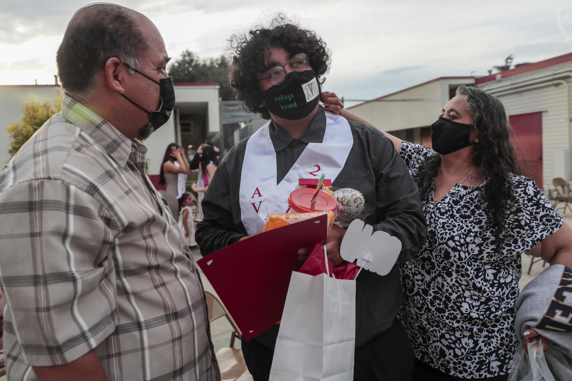 Patricia Medina straightens her son Jesus's collar as his father Felix Sr. looks on.