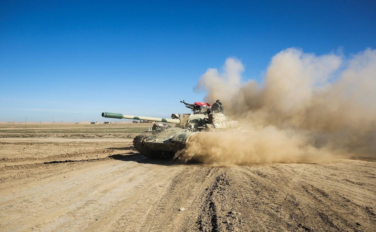 Iraqi tanks and armored vehicles advance toward the village of Sheikh Younis, south of Mosul, on Feb. 19