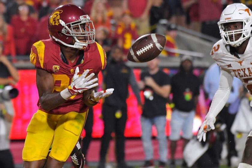 Southern California wide receiver Deontay Burnett, left, catches a pass for a touchdown as Texas defensive back Kris Boyd defends during overtime of an NCAA college football game, Saturday, Sept. 16, 2017, in Los Angeles. USC won 27-24. (AP Photo/Mark J. Terrill)