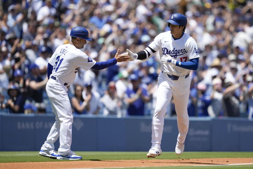 Los Angeles Dodgers designated hitter Shohei Ohtani celebrates with third base coach Dino Ebel (91) after hitting a home run during the first inning of a baseball game against the Atlanta Braves in Los Angeles, Sunday, May 5, 2024. (AP Photo/Ashley Landis)
