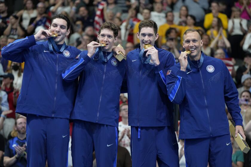 The U.S. United States men's 4x100 meter freestyle relay team celebrates on the podium after winning gold medals