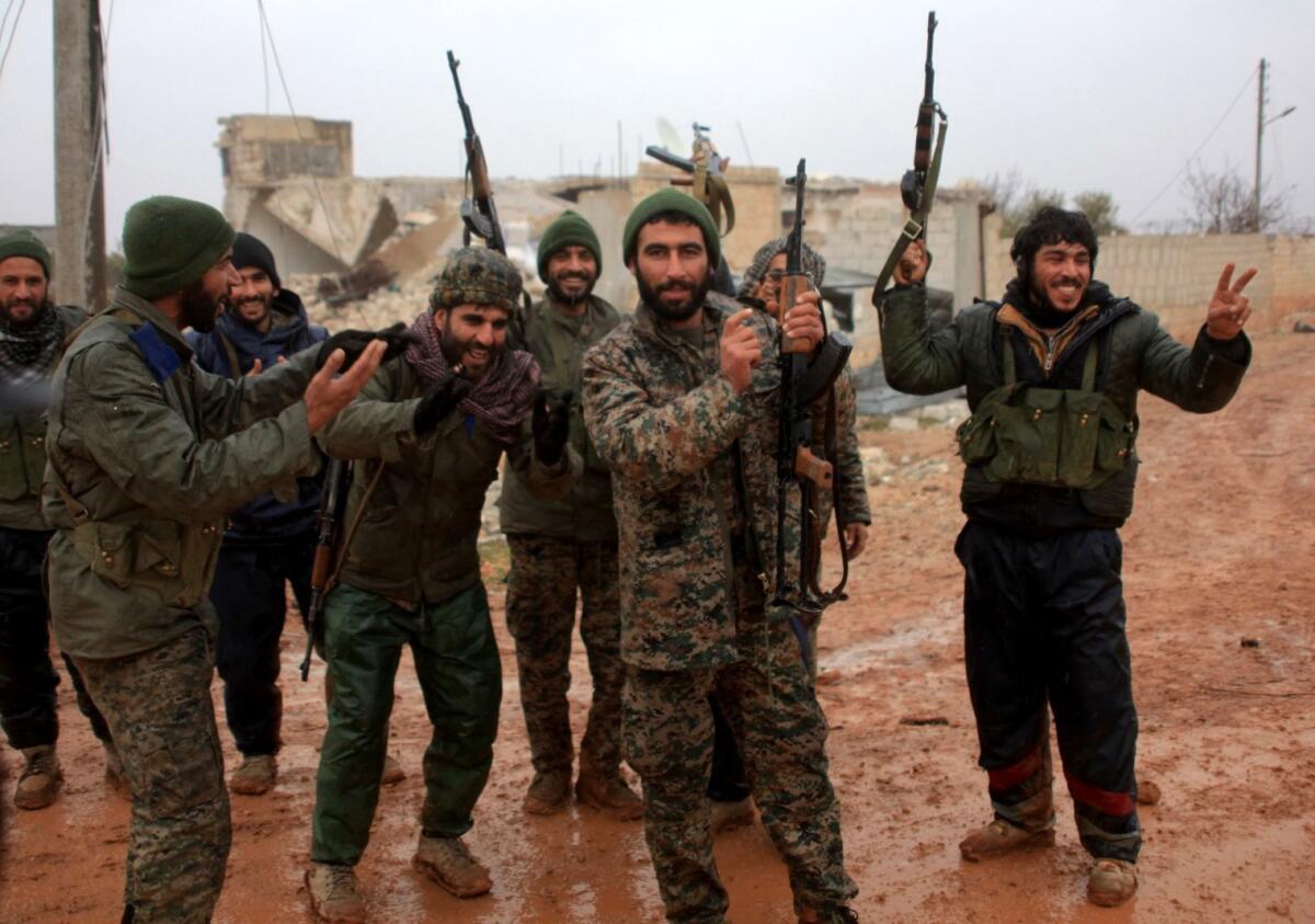 Syrian government soldiers celebrate after taking control of the village of Ratian, north of Aleppo, on Feb. 6, 2016.