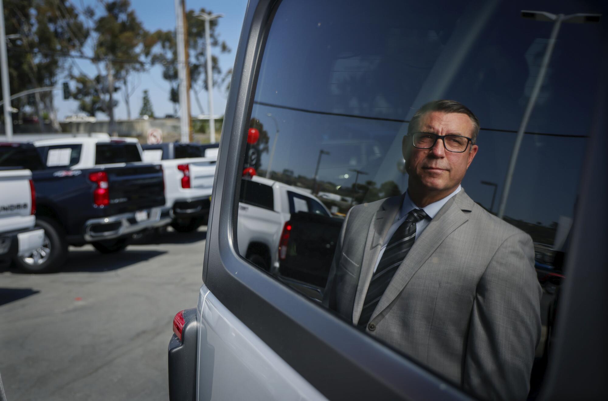 Attorney Michael Rogers stands at a Kia dealership in El Cajon.