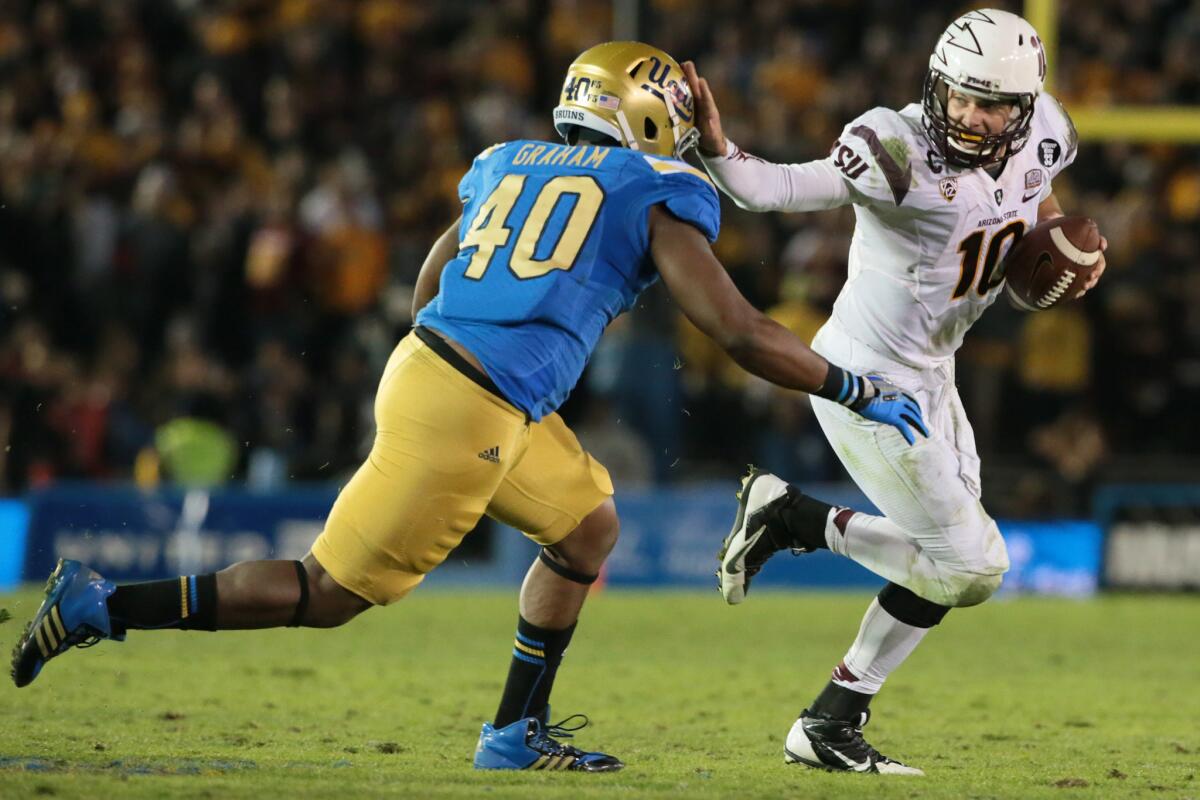 Arizona State quarterback Taylor Kelly runs from UCLA defensive end Keenan Graham last season.