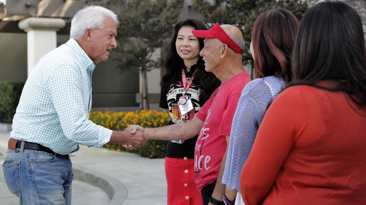 Republican gubernatorial candidate John Cox, left, greets David Tran, owner of Huy Fong Foods in Irwindale, and employees Wednesday as he kicks off his campaign bus tour.