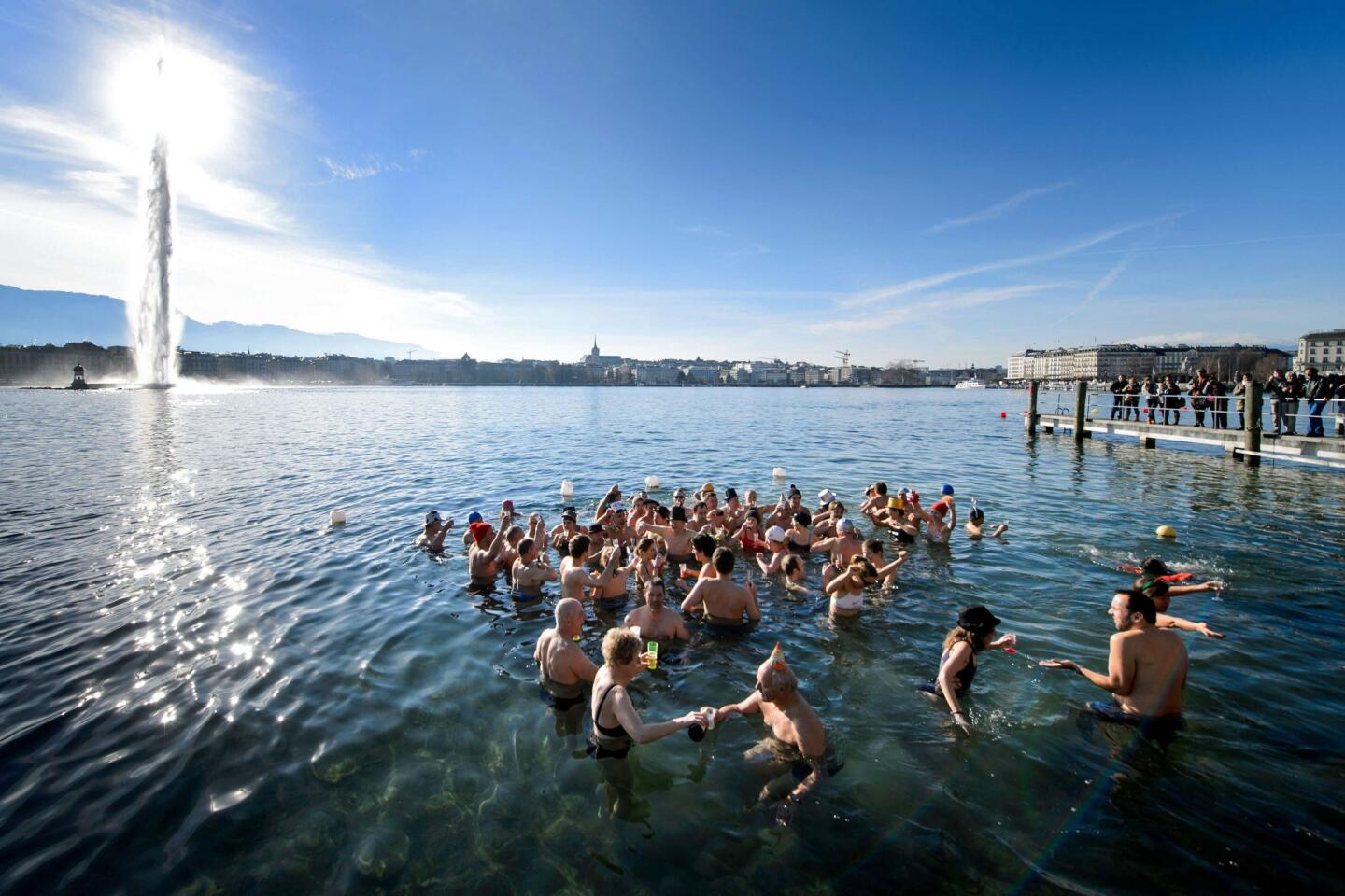 People hold glasses of sparkling wine as they celebrate the new year with a dip into the chilly waters of Lake Geneva in Switzerland. About 60 swimmers took part in the 20th edition of the traditional bath.
