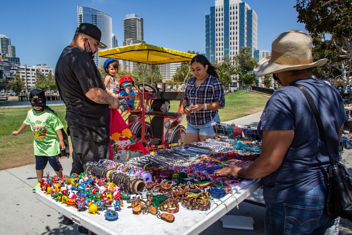 Angelica and Eric Cervantes shop at a street vendor for masks and costumes in San Diego in July