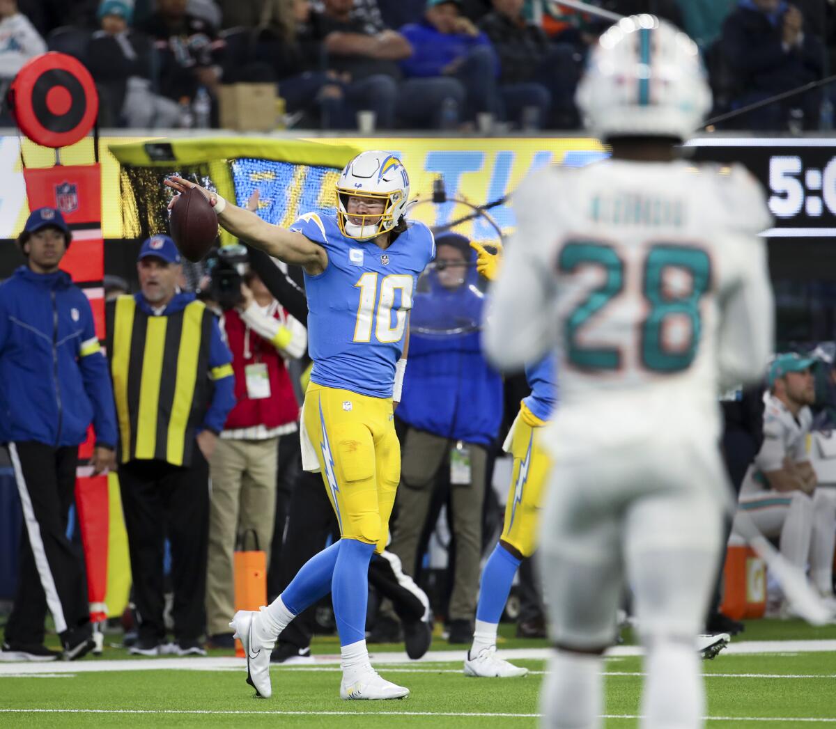 Chargers quarterback Justin Herbert signals first down after his run against the Dolphins.