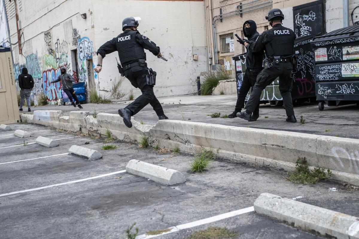 An LAPD officer chases a suspected looter in an alley behind Hollywood Boulevard.