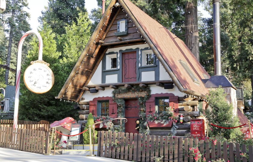 An A-frame alpine house decorated with a candy cane clock stand at SkyPark at Santa's Village in Lake Arrowhead.