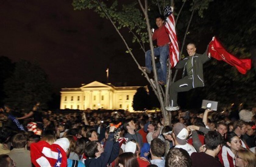 Crowds climb trees and celebrate in Lafayette Park early Monday, May 2, 2011, in front of the White House in Washington after President Barack Obama announced that Obama bin Laden had been killed. (AP Photo/Charles Dharapak)