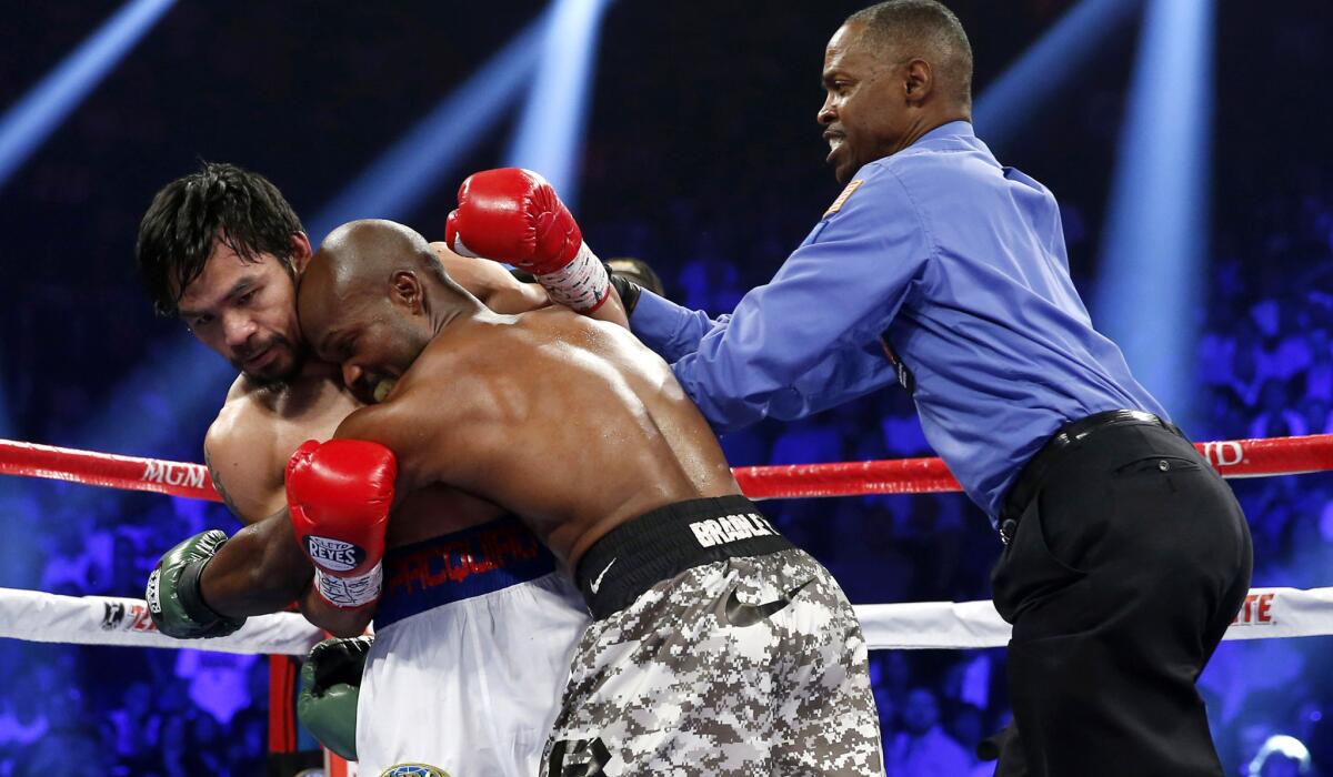 Referee Kenny Bayless works to separate Manny Pacquiao and Timothy Bradley during a WBO welterweight title fight on April 12, 2014. Bayless has worked fights for Floyd Mayweather Jr. too