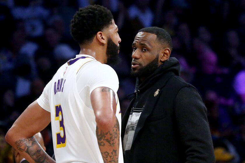 LOS ANGELES, CALIF. - DEC. 22, 2019. Lakers stars Anthony Davis, left, and LeBron James talk during a break in the action against the Nuggets in the second quarter Sunday night, Dec. 22, 2019, at Staples Center in Los Angeles (Luis Sinco/Los Angeles Times)
