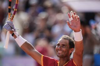 Rafael Nadal raises his arms in the air and celebrates his victory over Marton Fucsovics during the Paris Olympics.