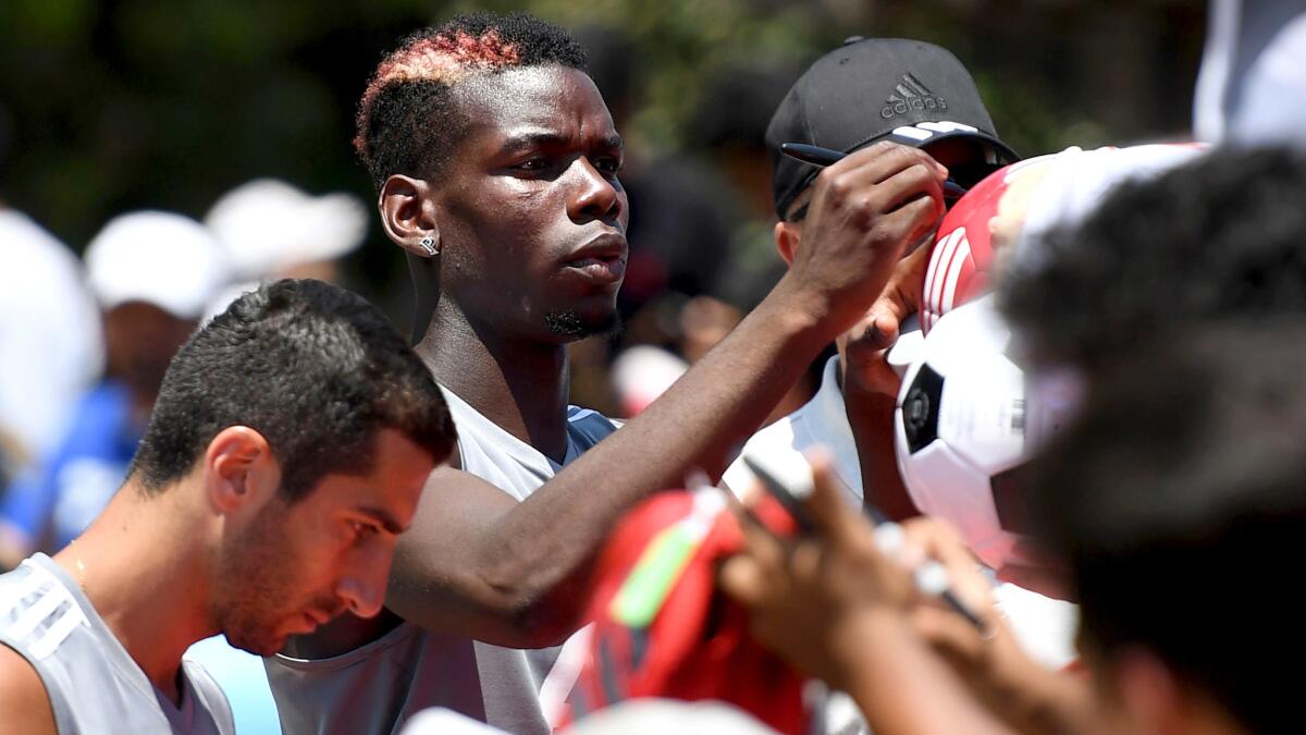 Manchester United's Paul Pogba signs autographs at UCLA on Friday after the team's training session.