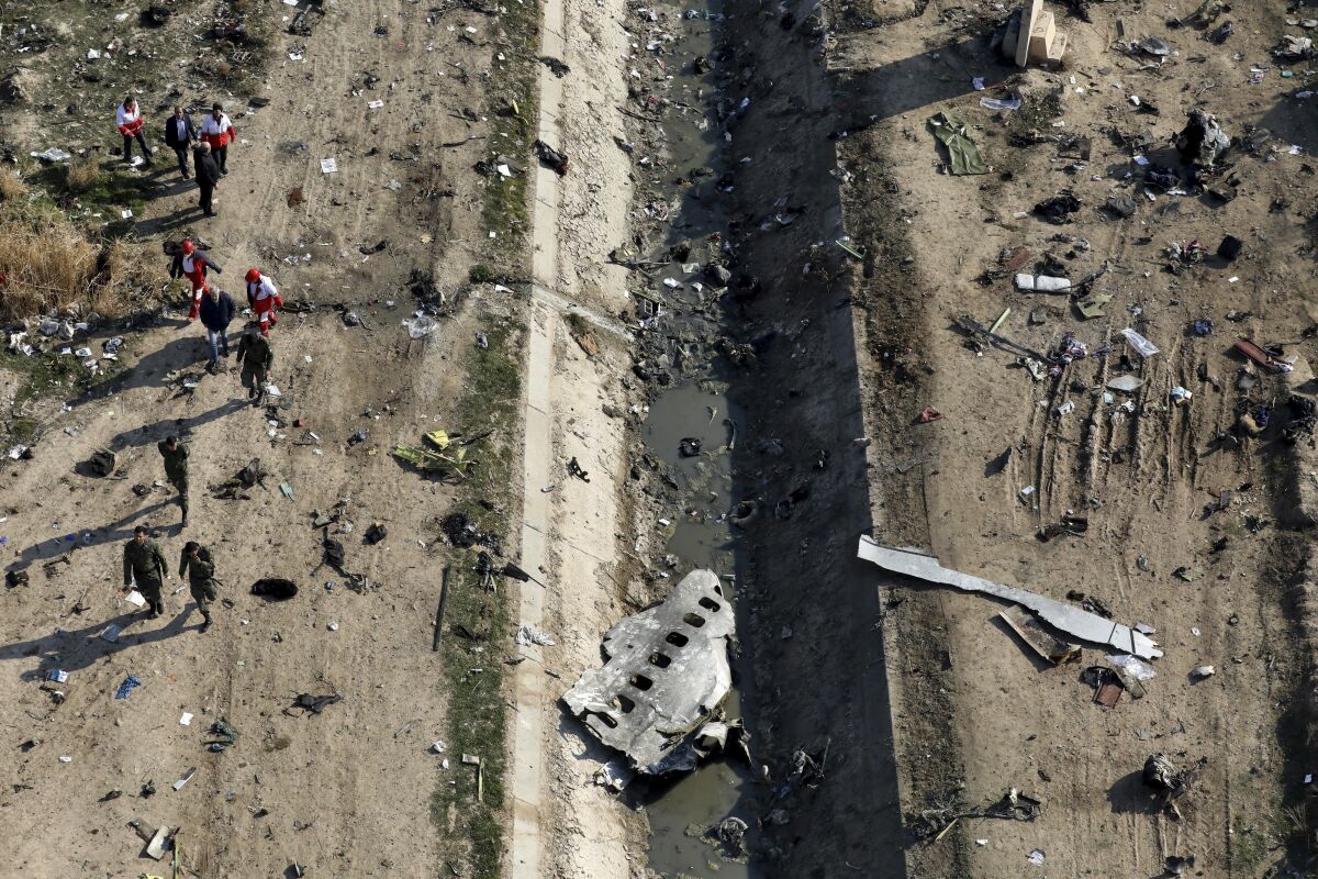 Rescue workers search the scene where a Ukrainian plane crashed in near Tehran in January.