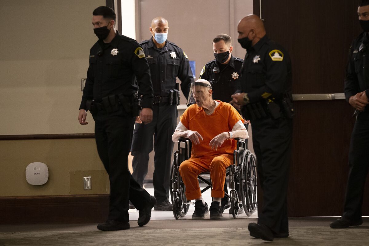 Deputies use a wheelchair to bring Joseph James DeAngelo into the courtroom 