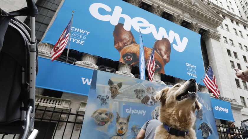 A dog named Frankie poses Friday outside the New York Stock Exchange, which is decorated for the Chewy IPO.