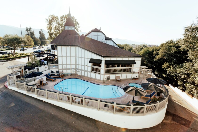 A building styled like traditional Danish architecture with a swimming pool