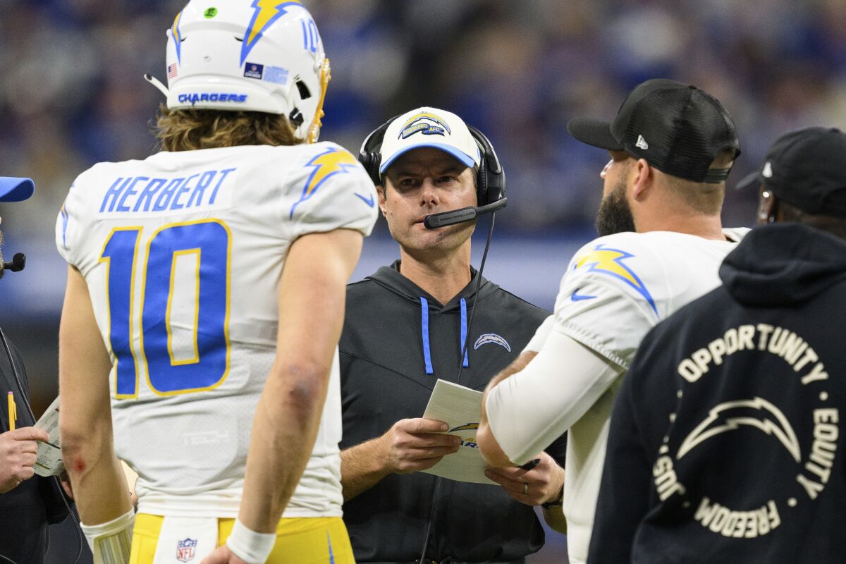 Chargers head coach Brandon Staley speaks with quarterback Justin Herbert (10) in Indianapolis.