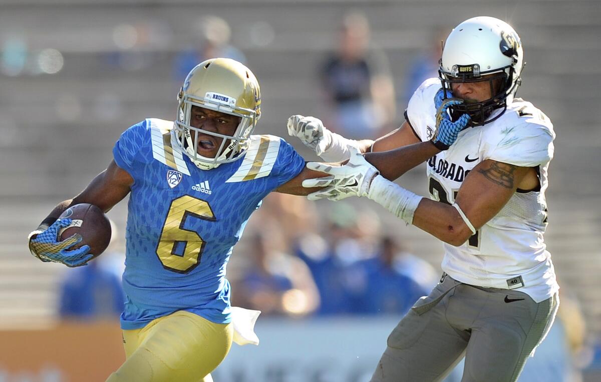 UCLA receiver Stephen Johnson III gives a stiff arm to Colorado safety Jered Bell on a kick return in the fourth quarter of the Bruins' 35-31 win over the Buffaloes on Oct. 31.